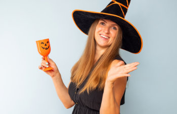 happy brunette woman in halloween witch costume